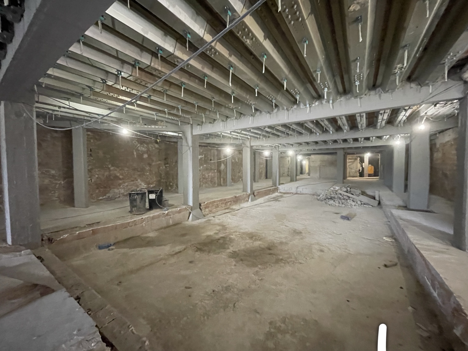 The DONDE club basement under construction: concrete columns supporting new steel reinforcement beams, exposed brick walls